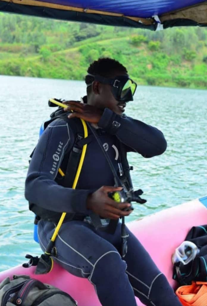 Diver adjusting mask on an inflatable boat with green hills behind
